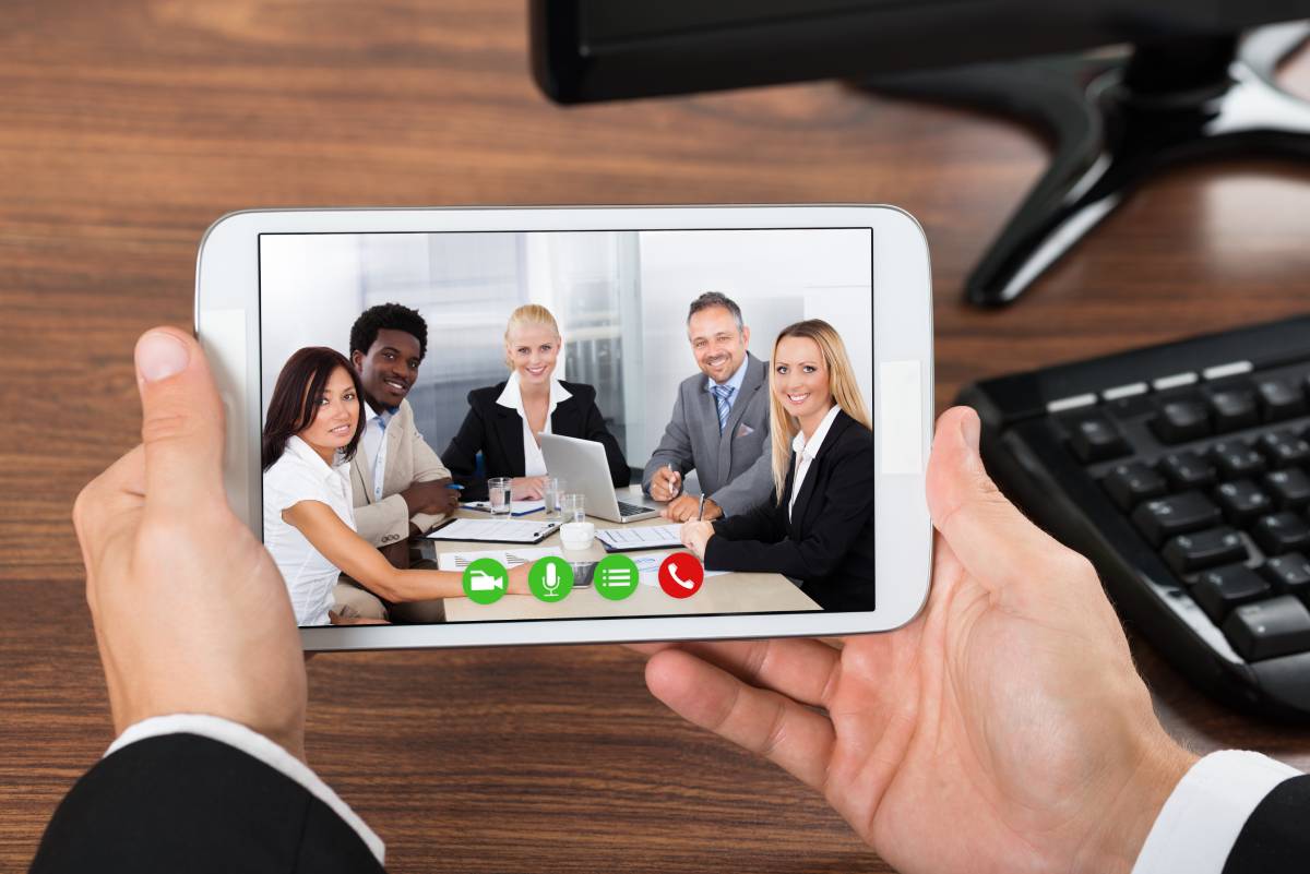 Businessman collaborating on video chat with team of business people