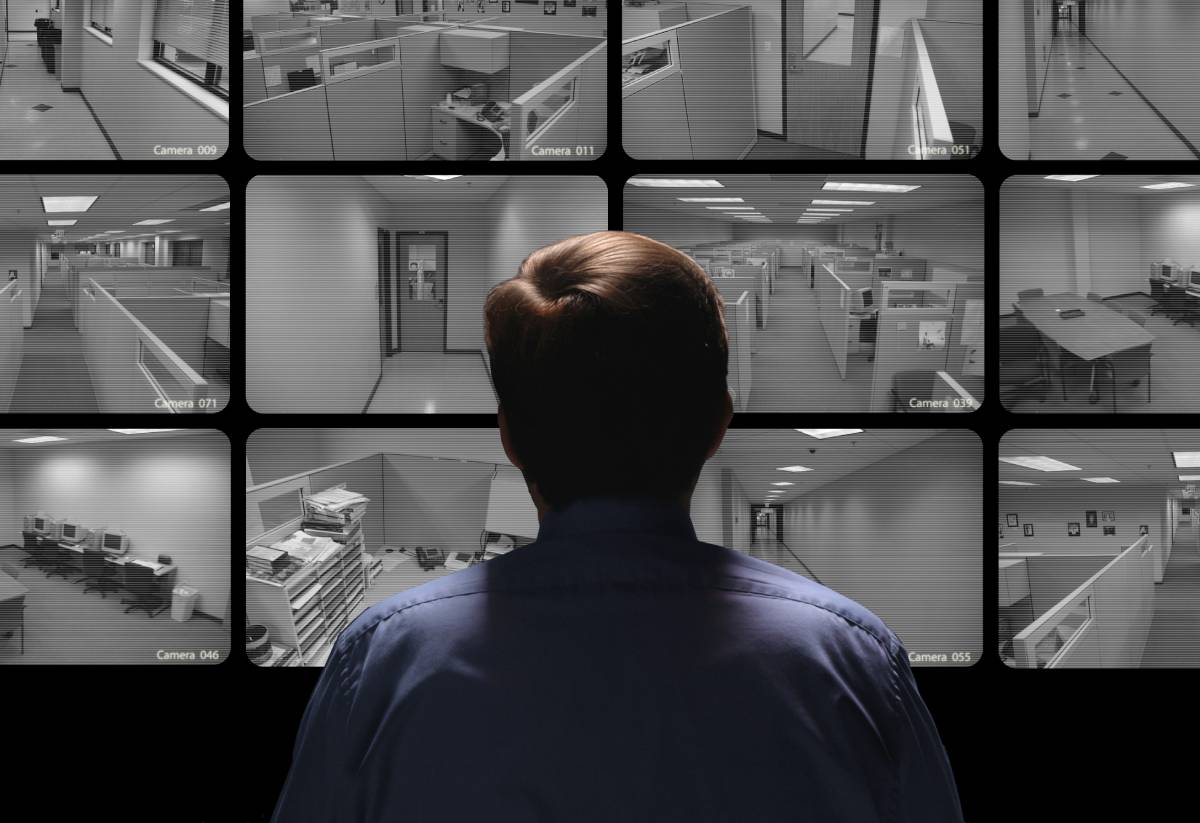 Man looking at different video surveillance screens